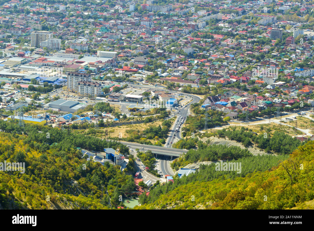 Aerial view of Gelendzhik resort city district from hill of caucasian mountains. Buildings and street at the foot of the mountains. Stock Photo