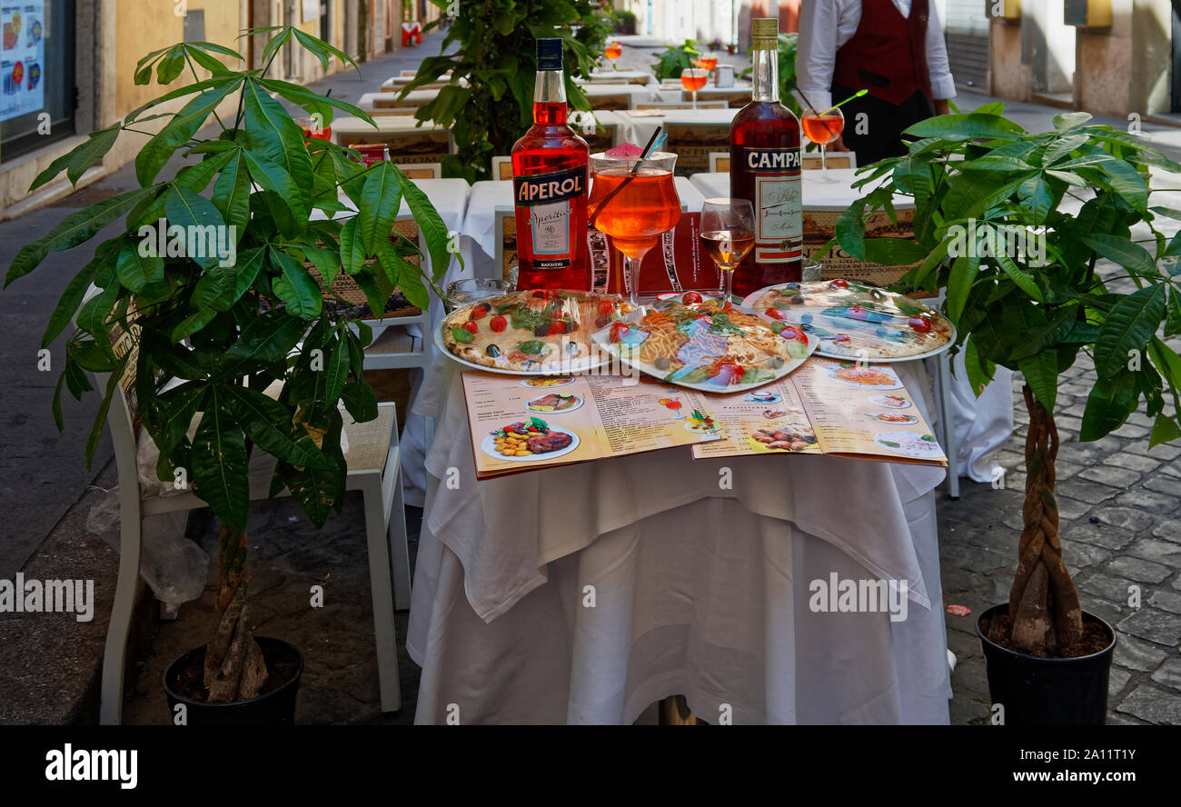 restaurant display; outdoor tables, food, wine, plants, menus; business; Rome; Italy; Europe; spring; horizontal Stock Photo