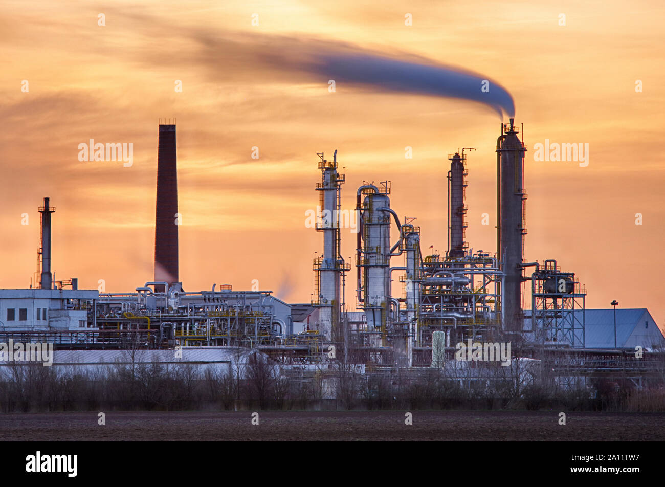Factory pipe polluting air, smoke from chimneys against sun, environmental problems, ecological theme, industry scene Stock Photo
