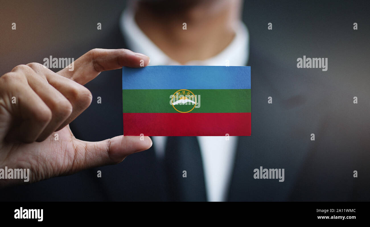 Businessman Holding Card of Karachay-Cherkessia Flag Stock Photo