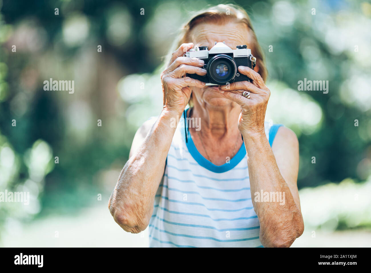 Elderly woman with a vintage film photo camera Stock Photo