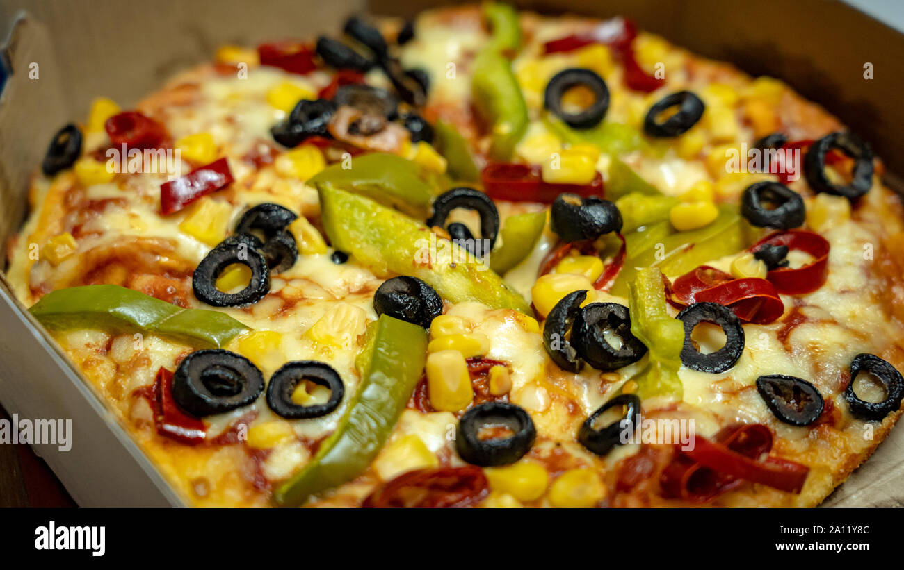 ballade Alle slags Tid A close up of a pizza with black olives, golden corn, red paprika and green  bell pepper topping Stock Photo - Alamy