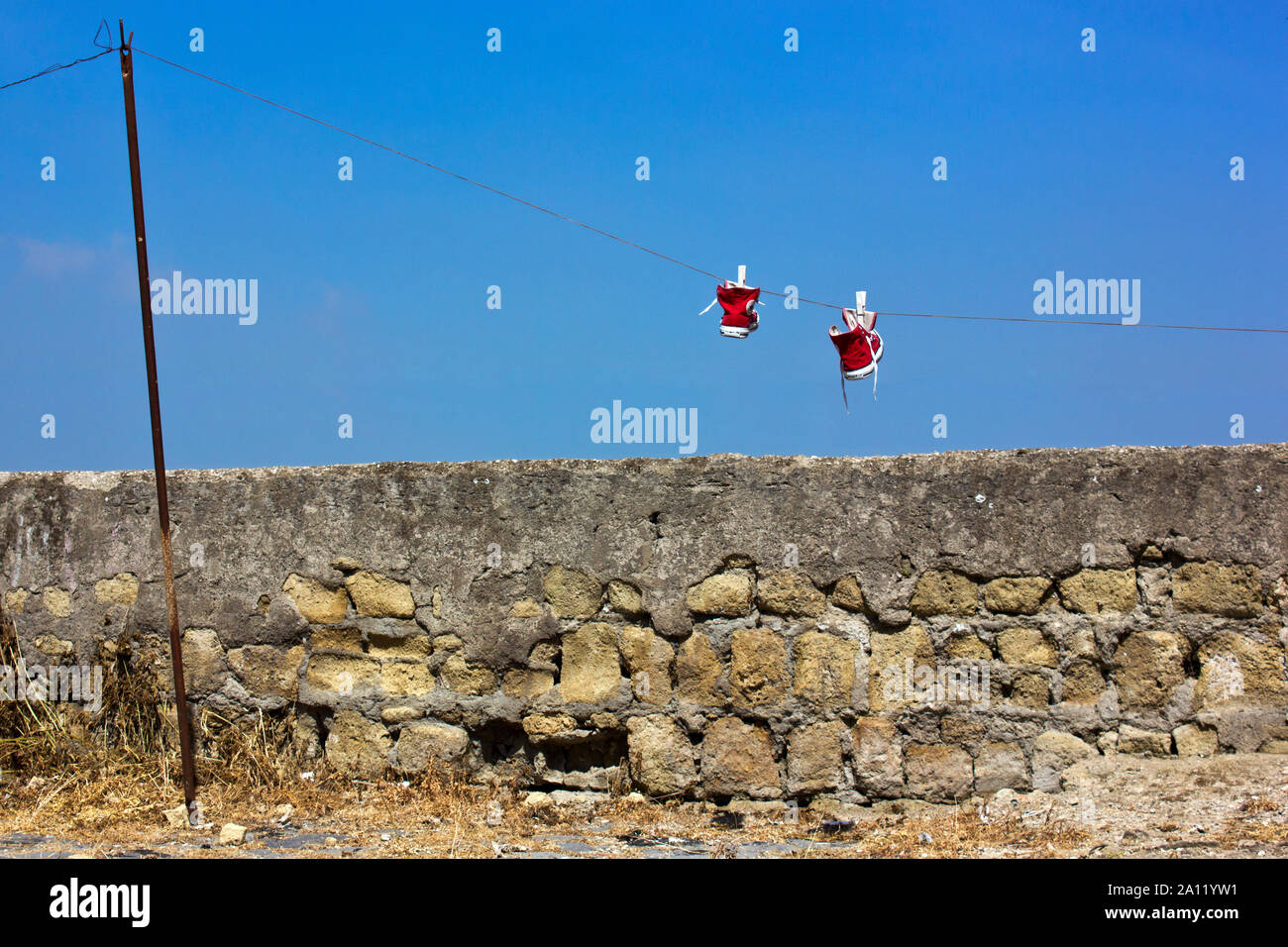 Kinderschuhe an Wäscheleine vor einer baufälligen Mauer in Neapel Italien Stock Photo