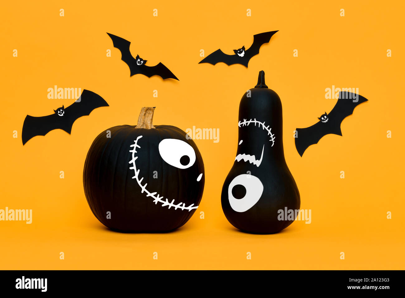 Cute Halloween pumpkins with funny smiling faces and paper bats flying ...