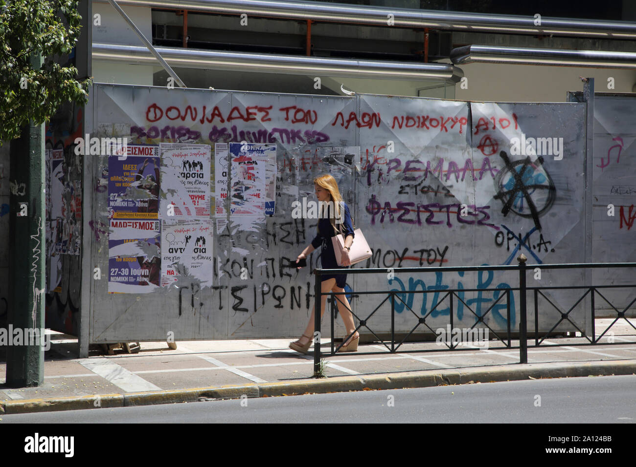 Athens Greece Woman Walking by Derelict Building with Graffiti on Stadiou Street Stock Photo