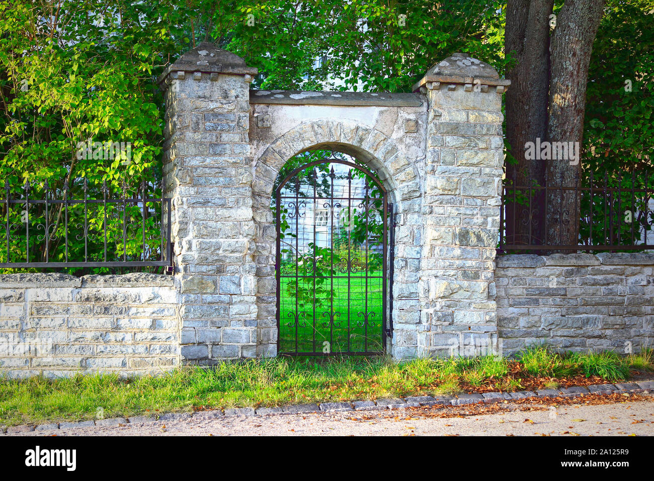 Old stone wall and iron gate on a late summer evening in Helsinki, Finland. Stock Photo