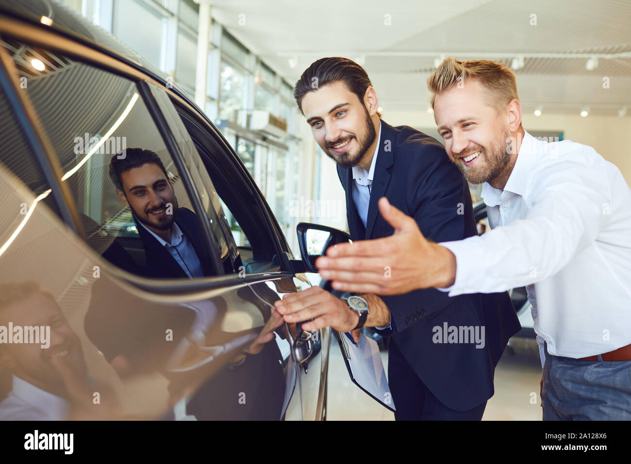 Auto business. Male buyer look at a new car. Stock Photo