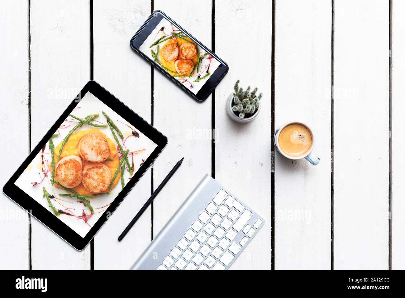 food blog background Desk for food blogger with tablet and smart phone with food photographs Stock Photo