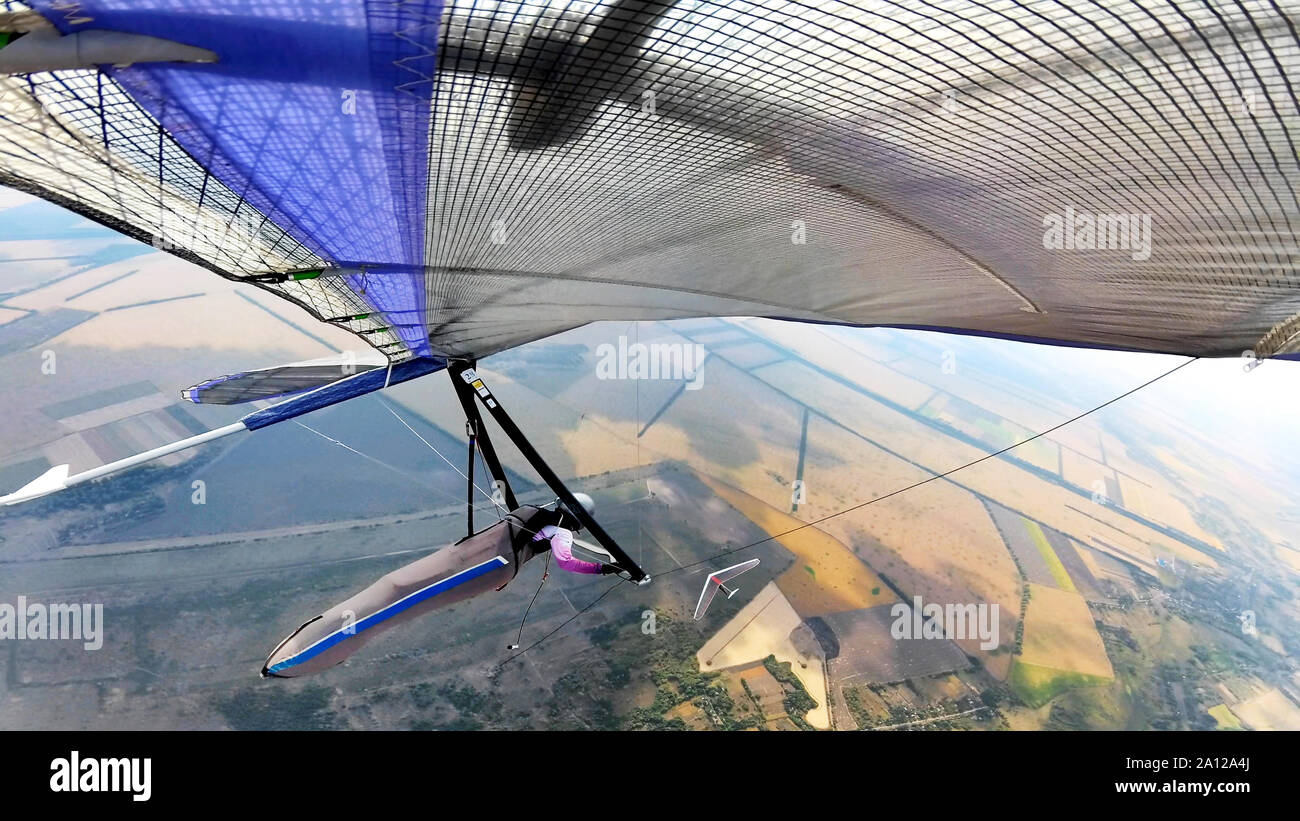 Hang glider on high altitude. Two pilots fly with their wings  high above ground. Stock Photo