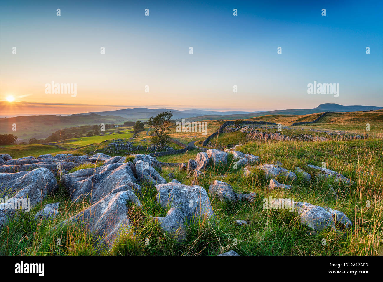 Sunset with clear blue skies over a limestone pavement at the Winskill Stones near Settle in the Yorkshire Dales National Park Stock Photo