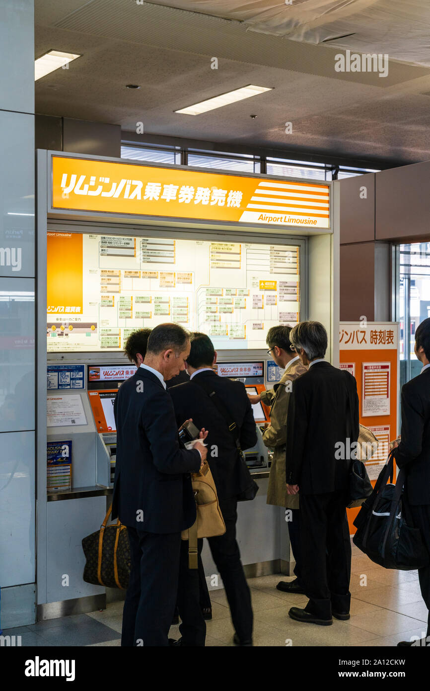 Tokyo Haneda international airport. Terminal one interior. Japanese salarymen using Airport Limousine ticket machine to buy tickets Stock Photo