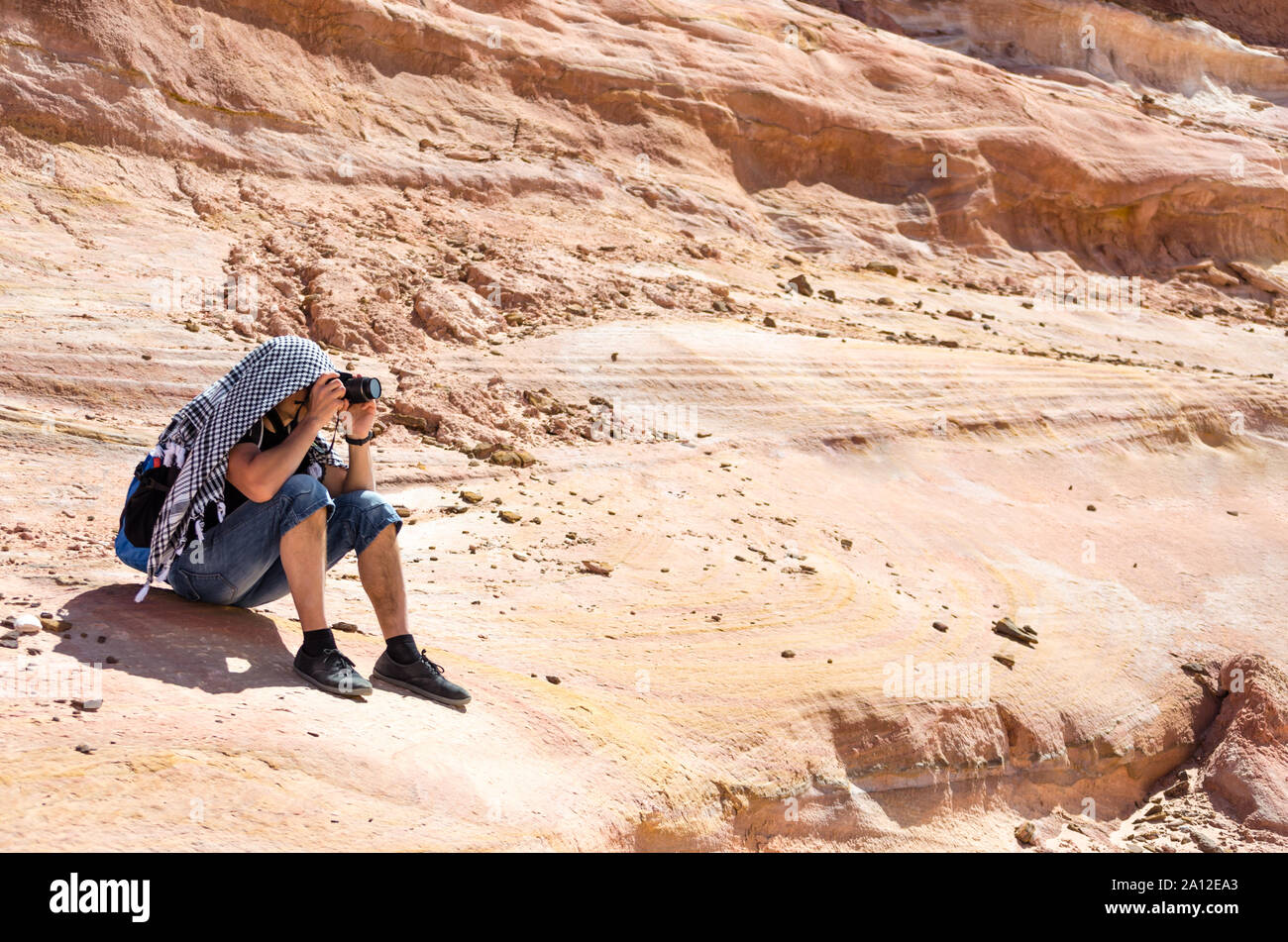 photographer takes pictures sitting on a rock in Egypt Dahab Stock ...