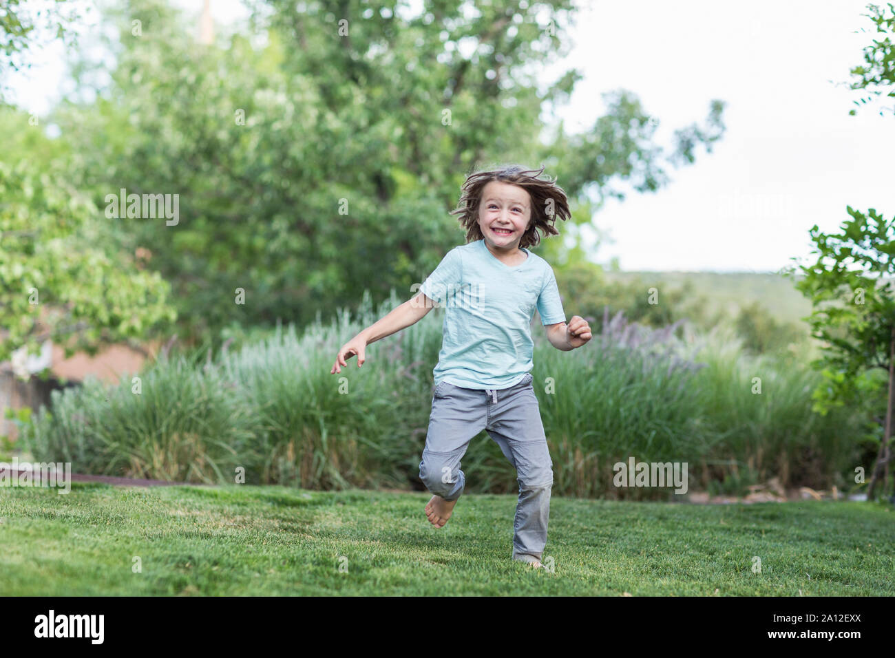 5 year old boy running on green lawn Stock Photo Alamy
