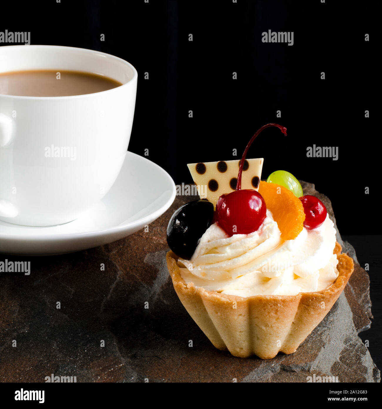 Fruit cake with cherries, grapes and plum stands on a wild stone next