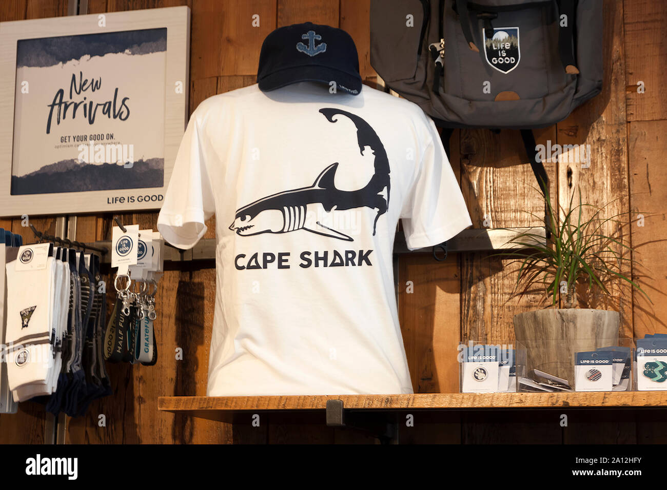 Shark themed tee-shirt and cap for sale on a store shelf in Chatham, Massachusetts, Cape Cod, United States. Stock Photo