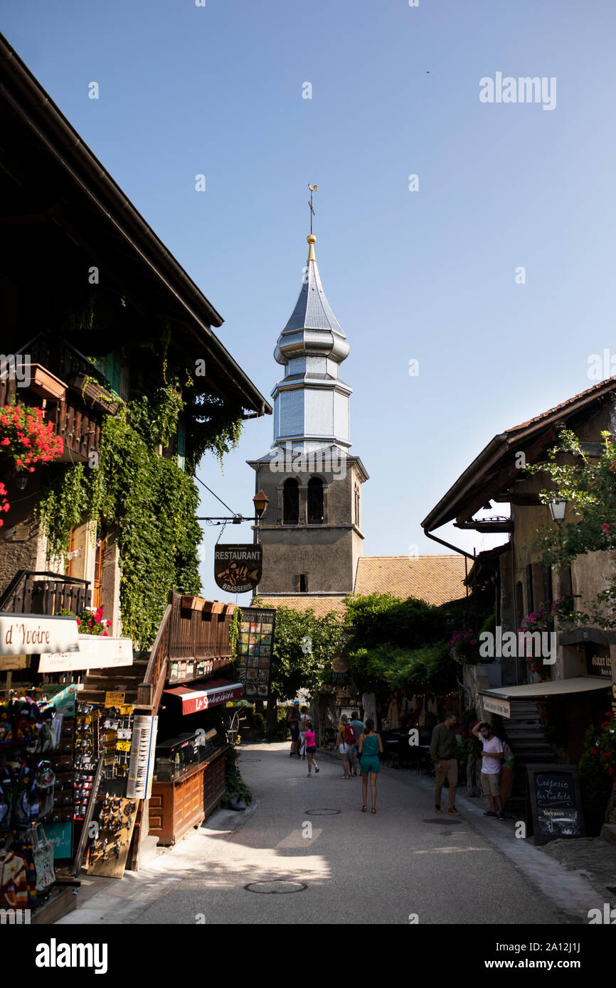 Shops and restaurants on the Rue de l'Église lead to the Saint Pancrace church in the medieval town of Yvoire, France. Stock Photo