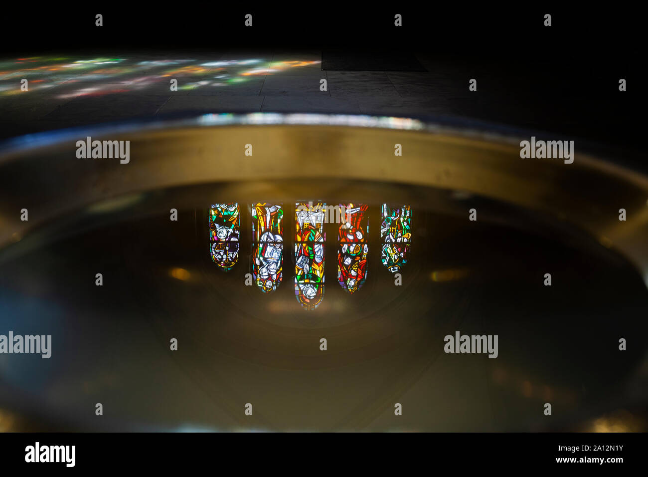 Luxembourg, Echternach, Basilique Saint-Willibrord, Stained-glass windows reflected in font water Stock Photo