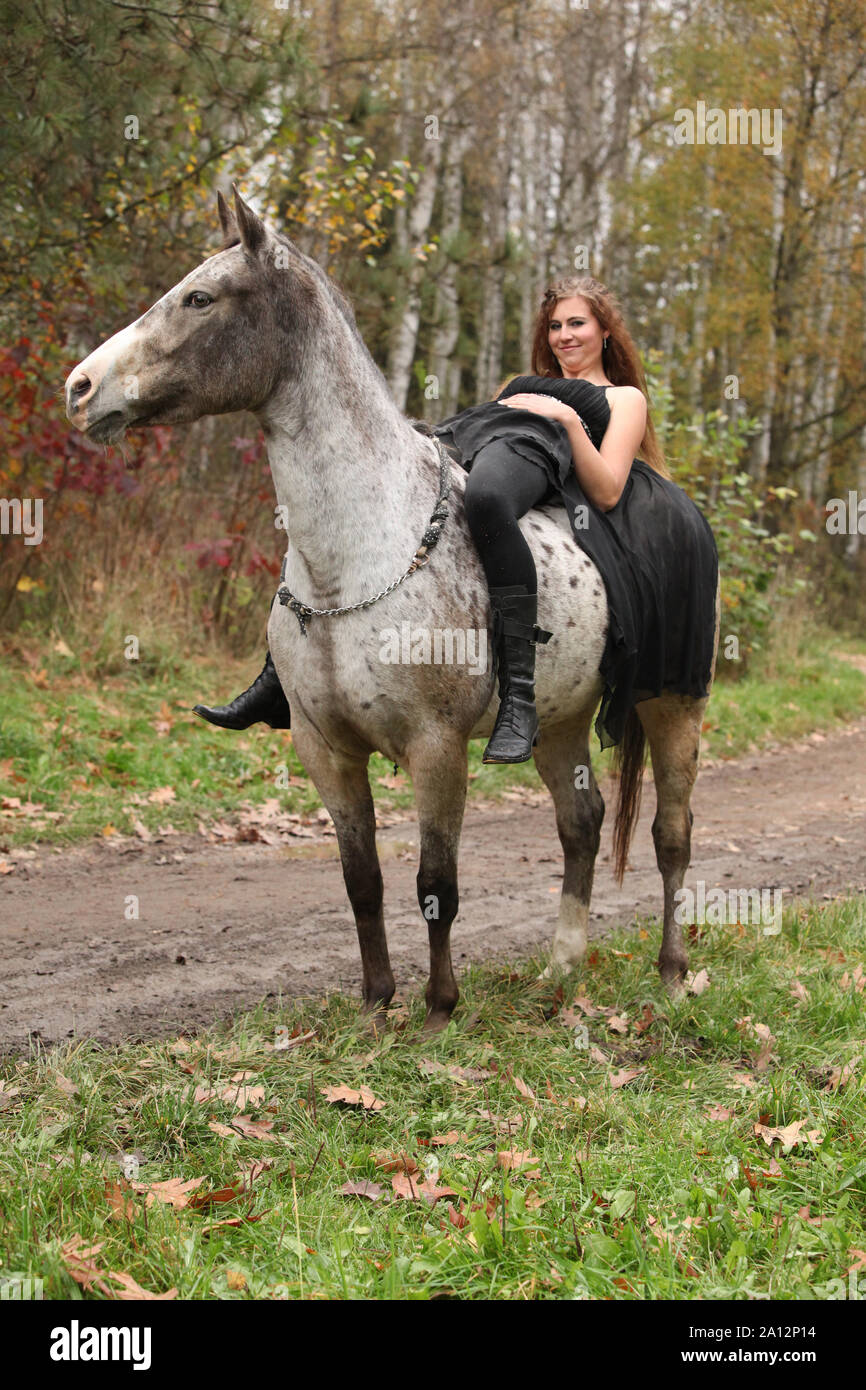 Amazing girl with long hair riding a horse without bridle Stock Photo