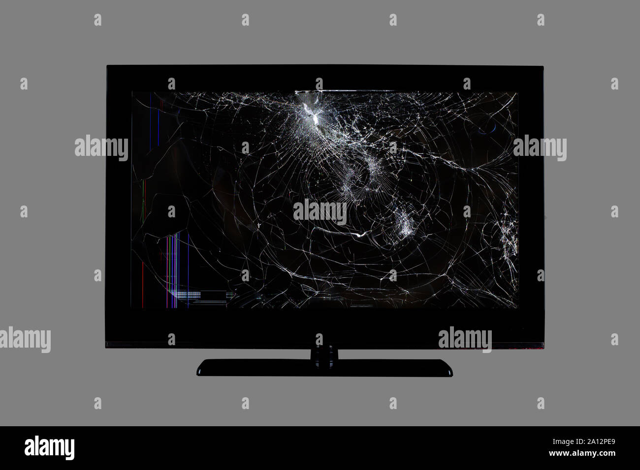 colored stripes and cracks on a black broken screen of a liquid crystal display, computer monitor or full hd television isolated on a grey background Stock Photo