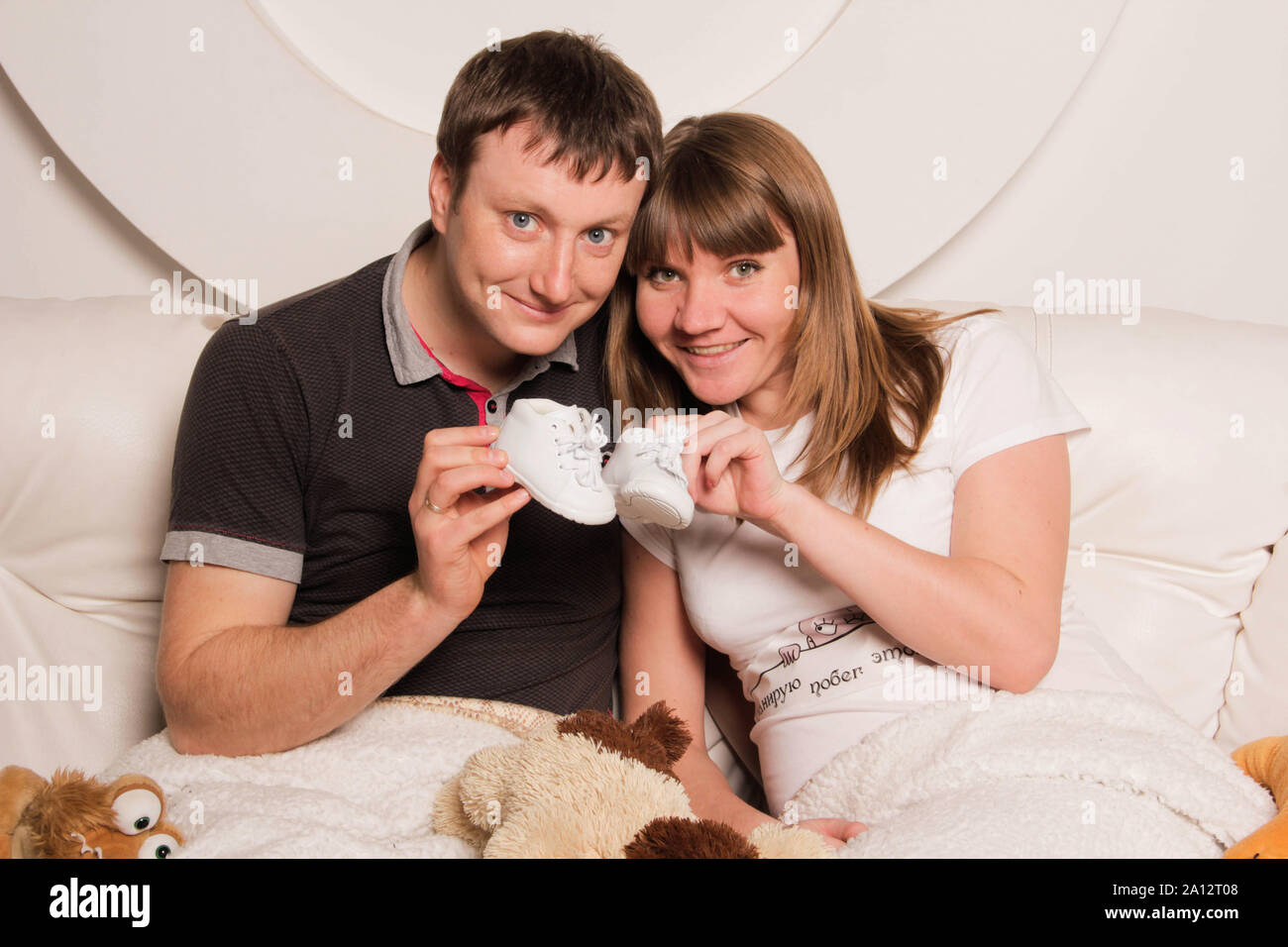 Zaporizhia, Ukraine - April 5, 2012: Portrait of happy future parents. The pregnant woman and the future father are holding little baby shoes Stock Photo