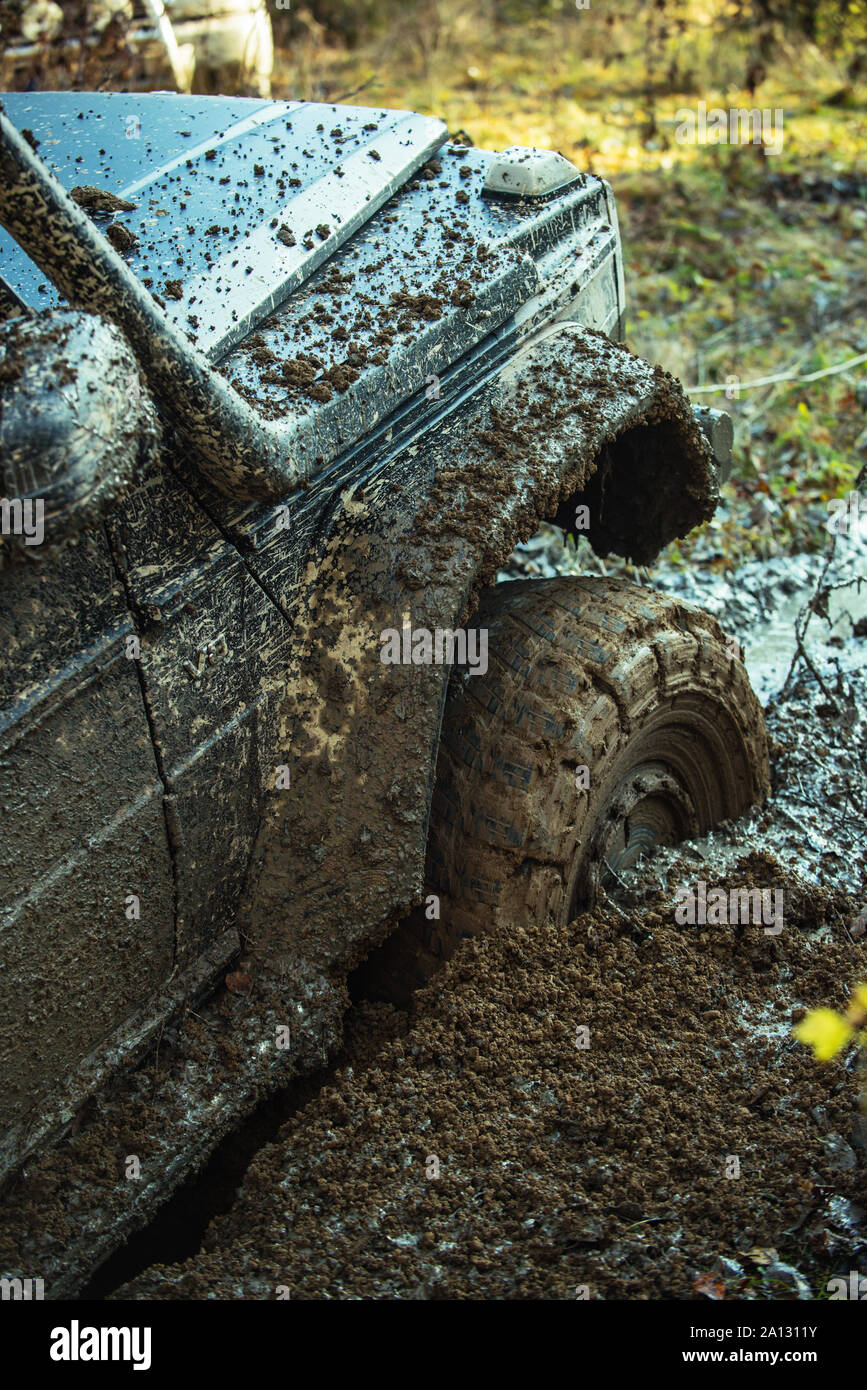 Fragment of car stuck in dirt, close up. Dangerous expedition concept