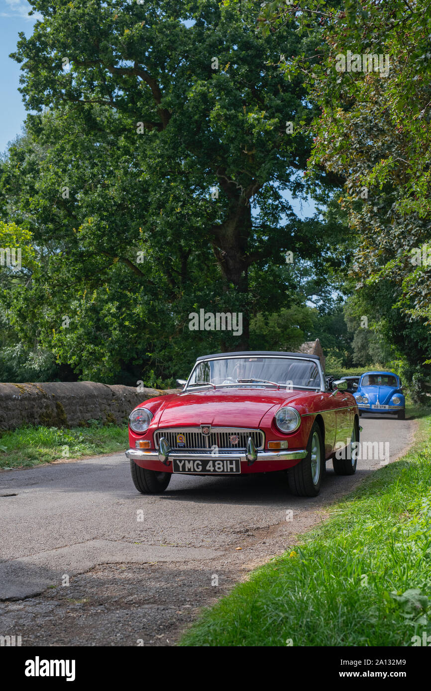 1970 MG B car leaving a classic car show in the Oxfordshire countryside. Broughton, Banbury, England Stock Photo
