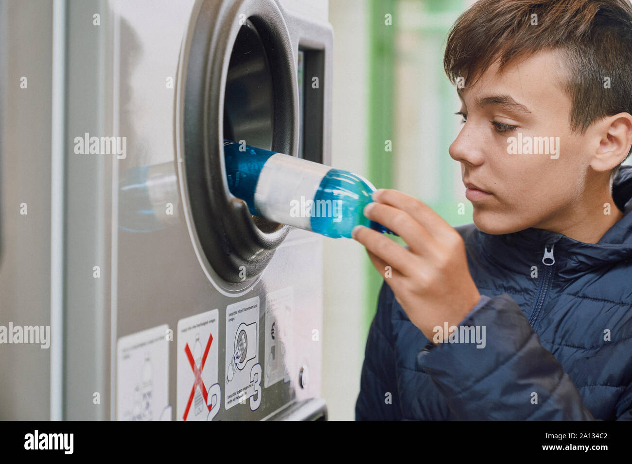 Child recycling plastic bottles in a machine Stock Photo Alamy