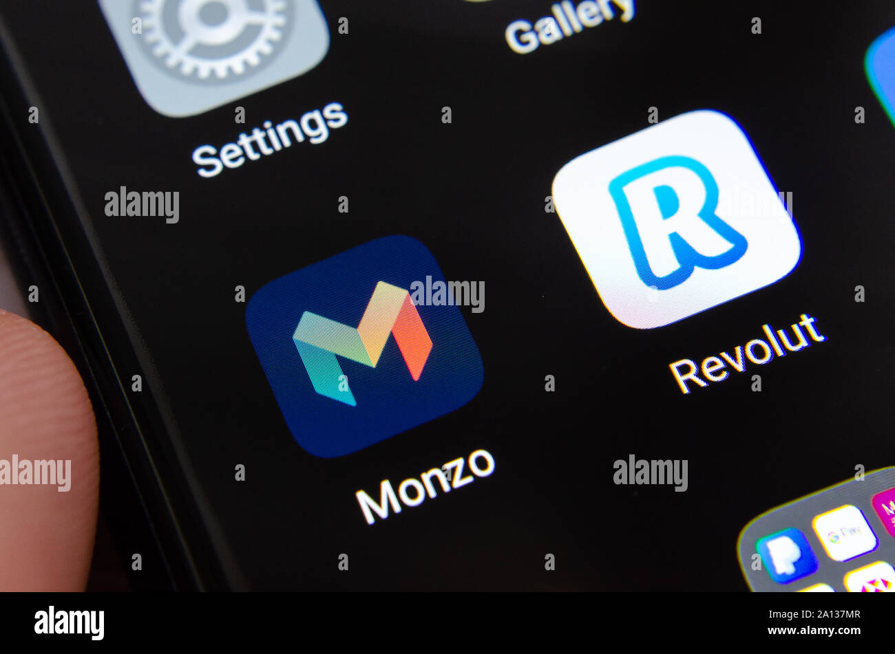 Monzo and Revolut bank apps on the smartphone hold in hands. Stock Photo