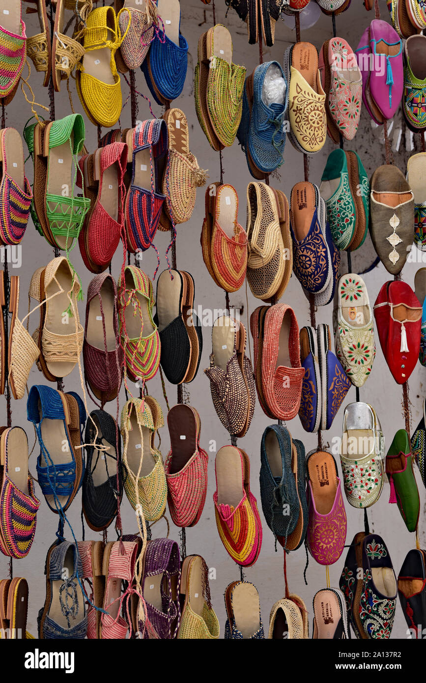 Colourful shoes for sale hanging outside a shop, a very typical scene throughout the town of Essaouira, Morocco, North Africa. Stock Photo