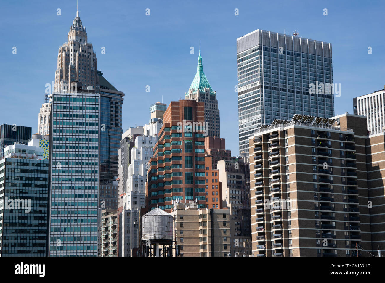 Viele unterschiedliche Hochhäuser nebeneinader gedrängt. Im Vordergrund der Betonwüste ist  ein Wasserturm zu sehen Stock Photo