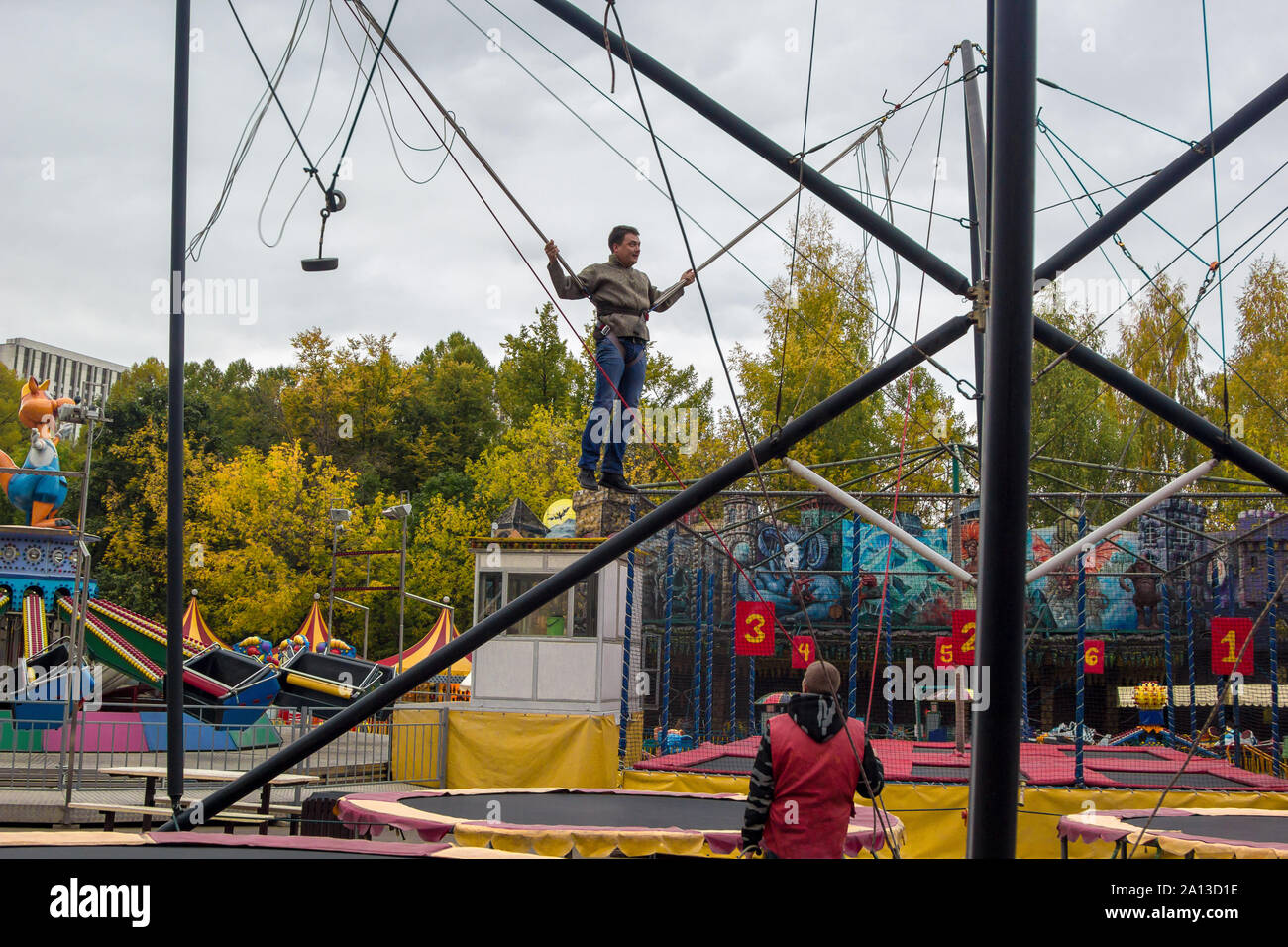 man jumps on a trampoline with an elastic band Stock Photo - Alamy