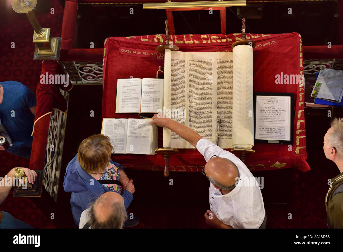 Traditional Torah scroll book in Synagogue being shown to people by rabbi in synagogue, Bristol, UK Stock Photo
