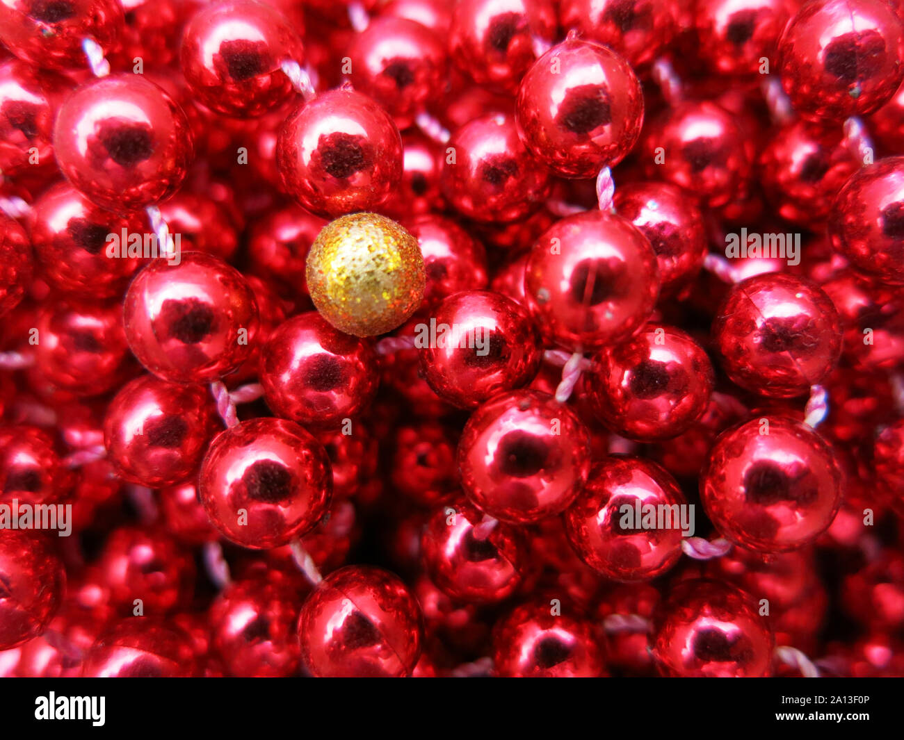 Yellow bead among red ones. (Concept diversity, difference, loneliness). Stock Photo