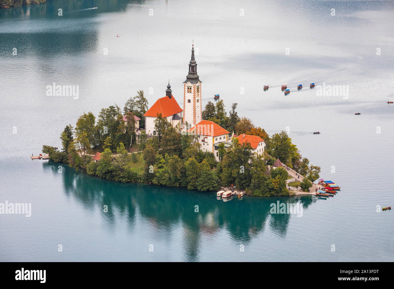 Church island with tourist boats on Bled lake in Slovenia Stock Photo