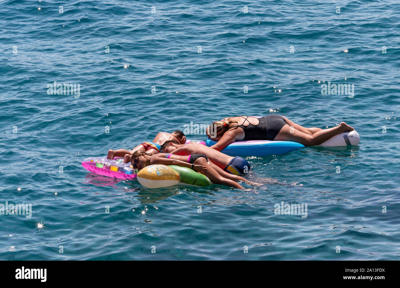 Swimmers resting on the air floaty on the sea Stock Photo