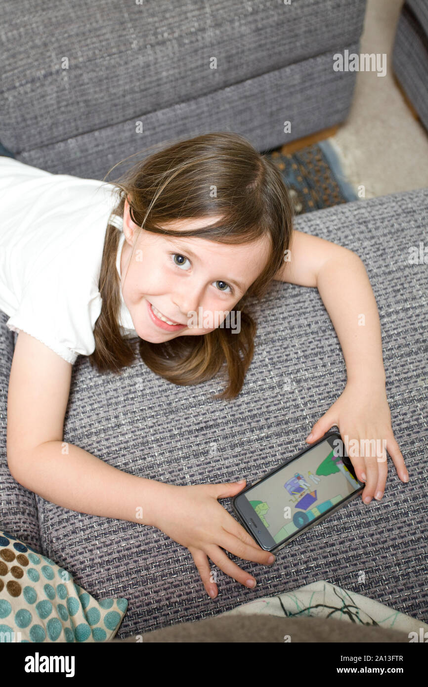 Young girl watching cartoons on her phone Stock Photo