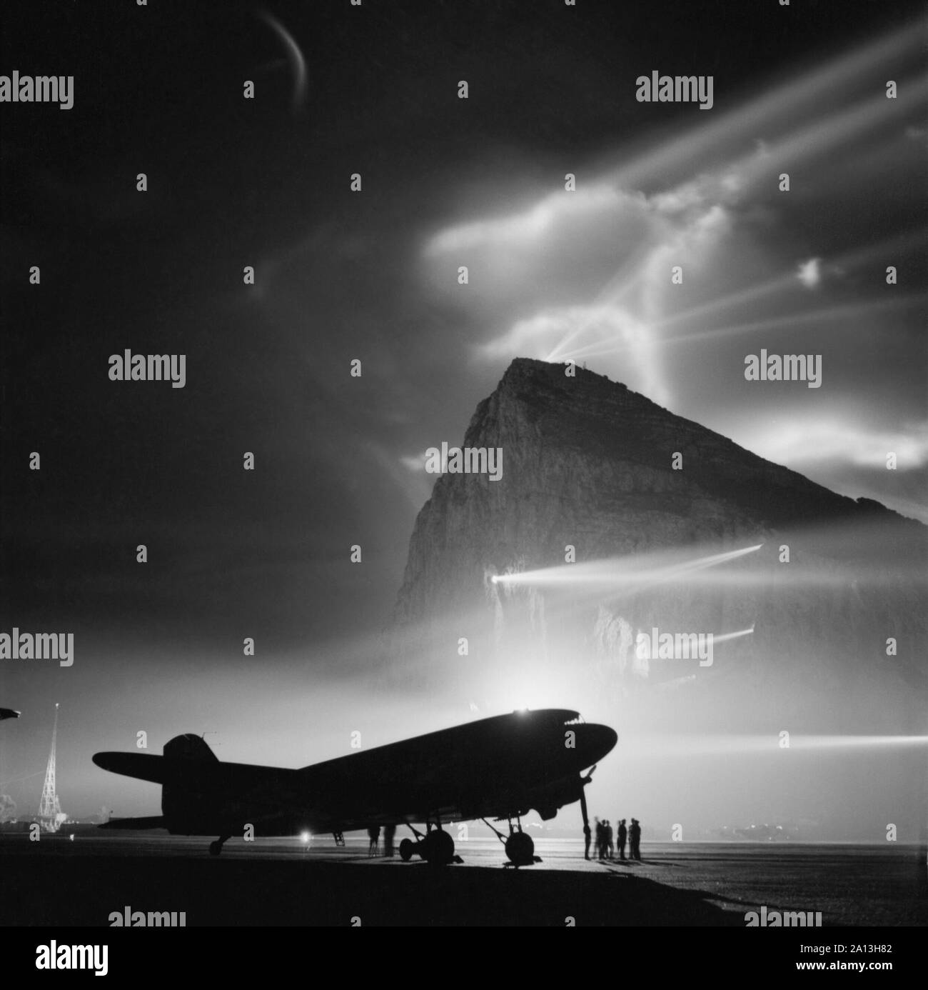 A Dakota passenger plane silhouetted by searchlights from The Rock of Gibraltar. Stock Photo