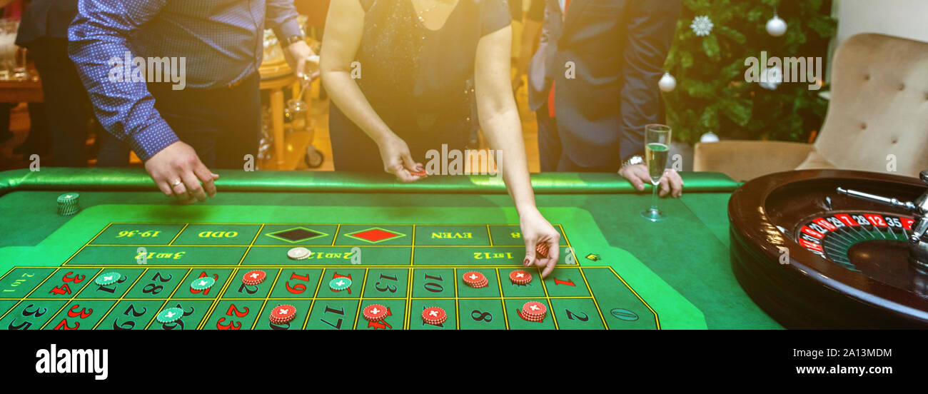 Group of people behind roulette gambling table in luxury casino. Friends  playing poker at roulette table with tape measure. Vegas games nightlife  lucky winning concept. Banner Stock Photo - Alamy