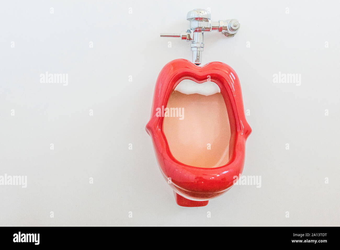 A red lips urinal with white teeth in the men's bathroom at the