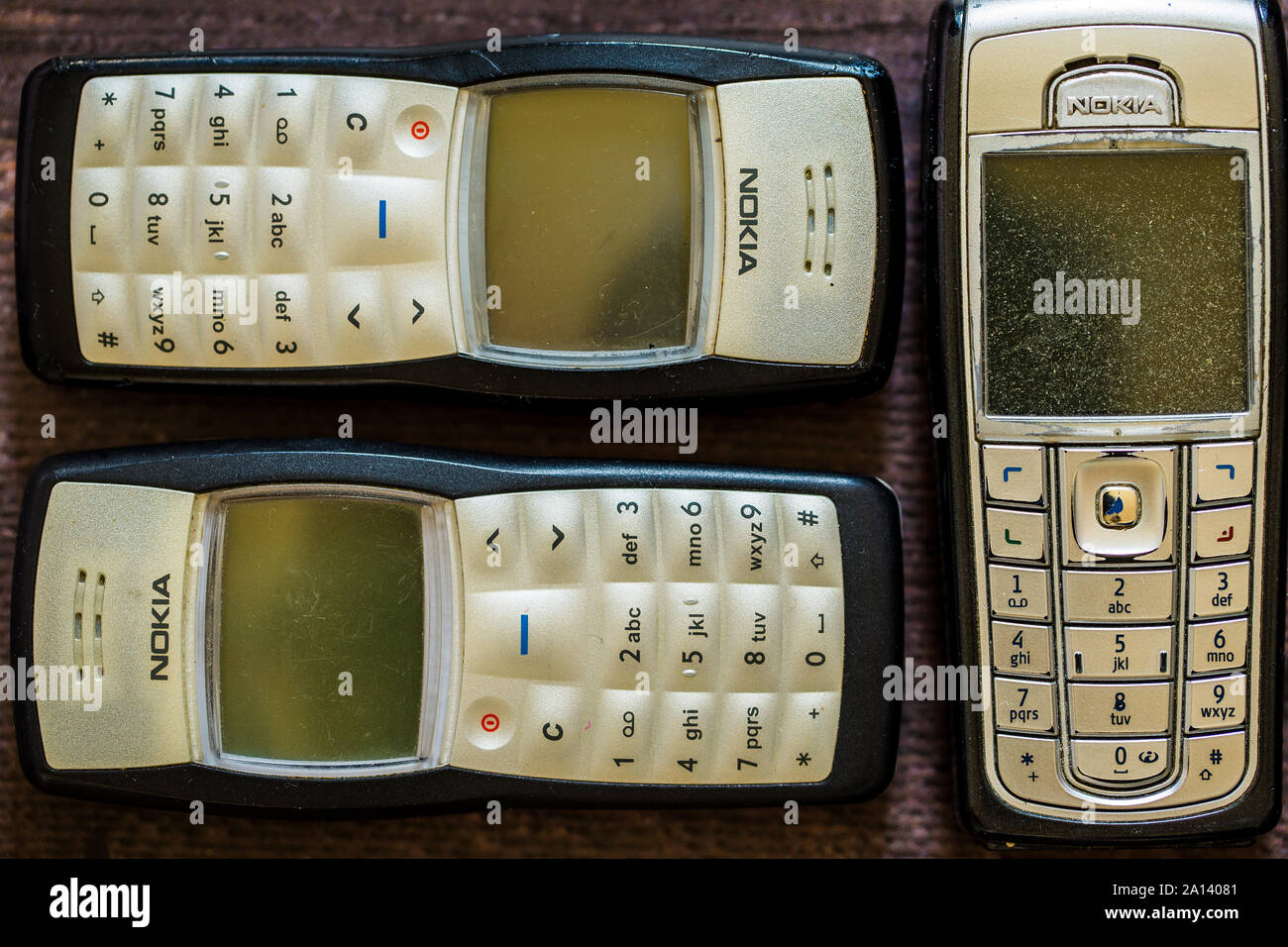 Old Nokia mobile phone laying on brown wooden floorboards. Stock Photo