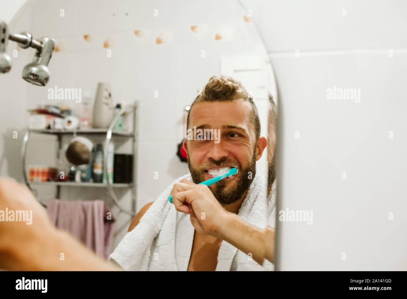 Man with toothbrush cleaning teeth at bathroom Stock Photo