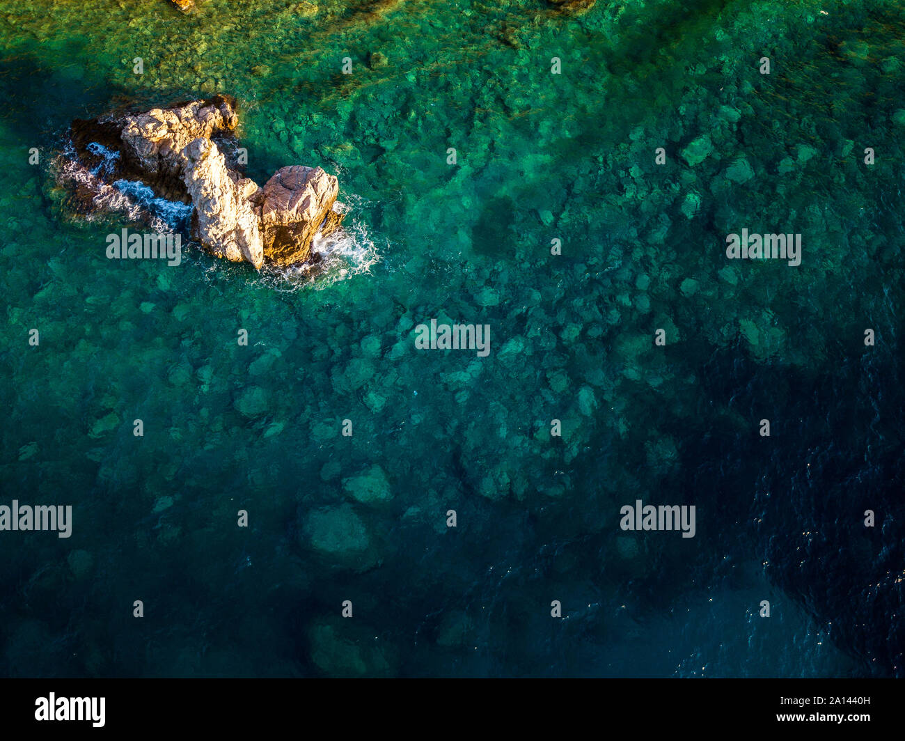 Aerial view of a seabed with rocks emerging from the sea, seabed seen from above, transparent water Stock Photo