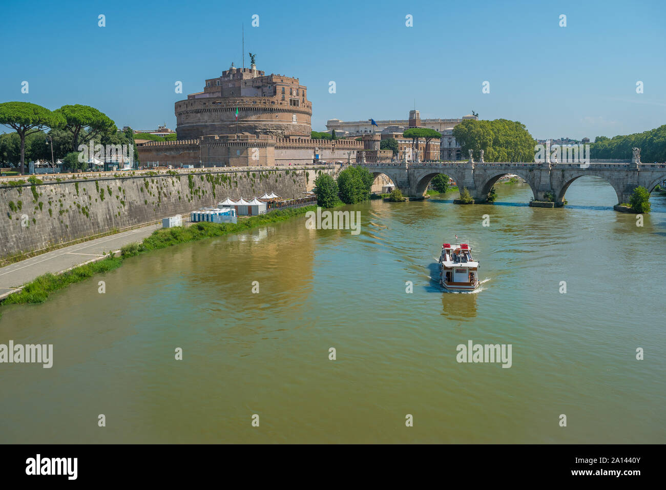 Tourist Boat and the Sant'Angelo Castle on the banks of the river Tiber in Rome, Italy Stock Photo