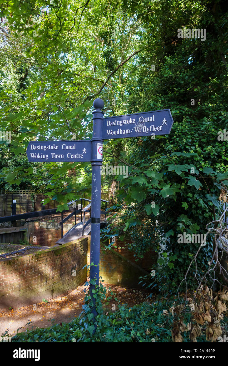 Signpost on the public footpath towpath on the Basingstoke Canal in Maybury near Woking with directions pointing to local places of interest Stock Photo