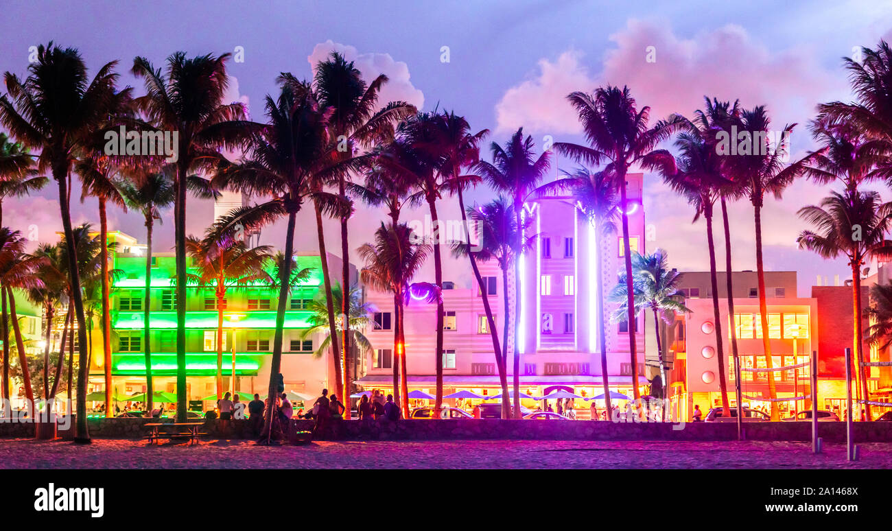 Miami Beach Ocean Drive hotels and restaurants at sunset. City skyline