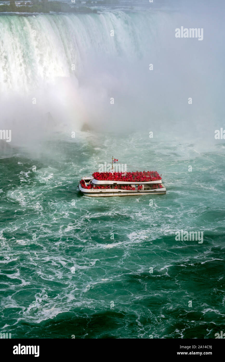 Boat carrying tourists at the bottom of Niagara Falls Stock Photo