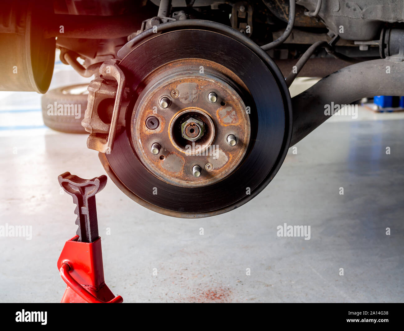 Old car brake disc without wheel and lift up by hydraulic for waiting