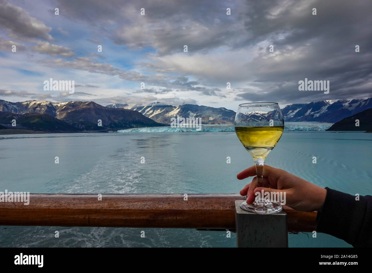 A woman drinking a glass of wine while their cruise ship is sailing away from the Hubbard Glacier. Stock Photo