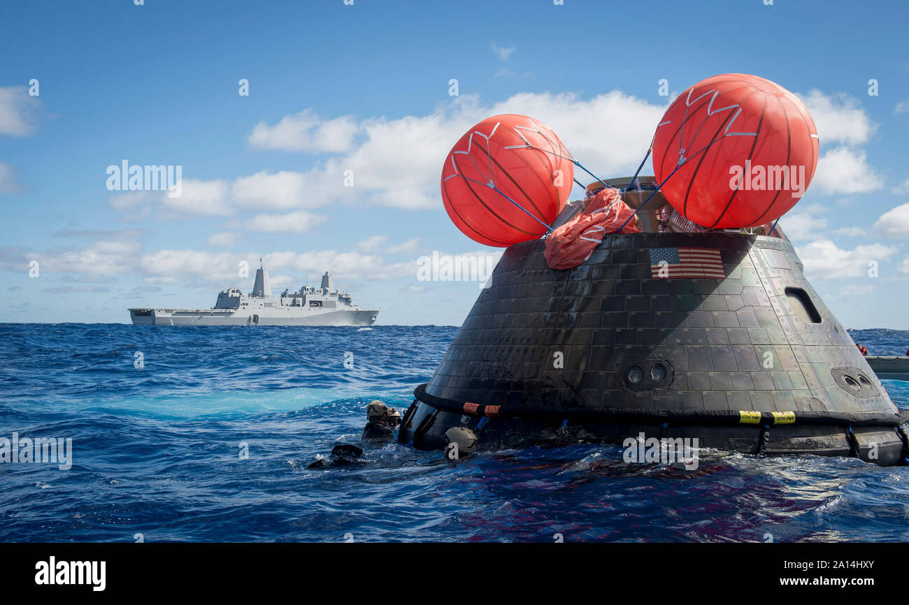 U.S. Navy divers attach a towing bridle to the NASA Orion crew module. Stock Photo