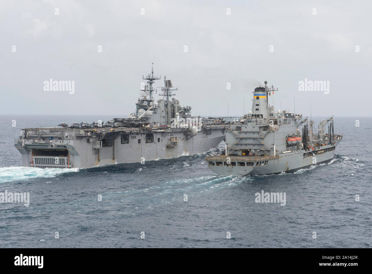 USS Iwo Jima conducts an underway replenishment with USNS Patuxent. Stock Photo